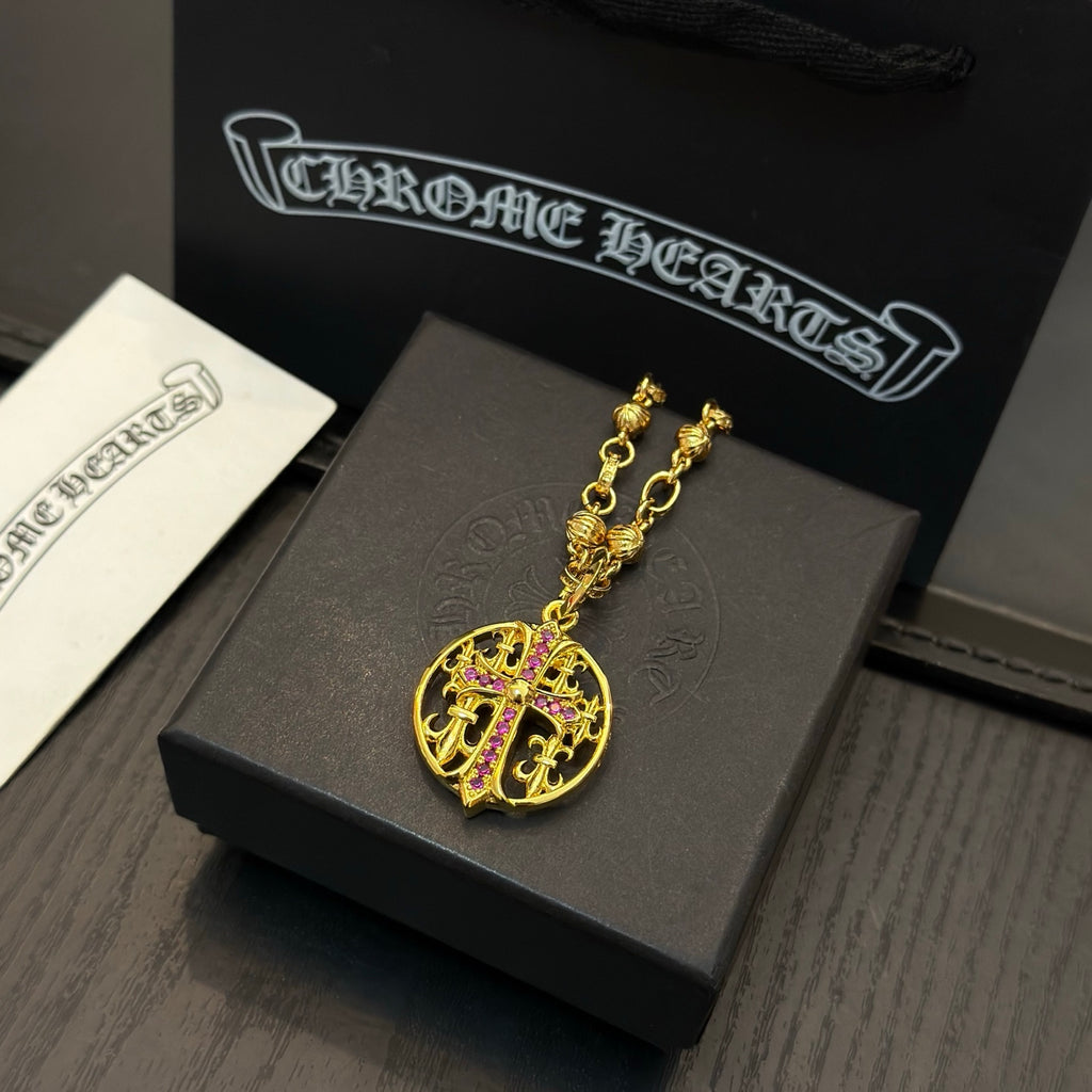 Gold-tone chain necklace with round red crest pendant on display.
