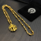 Gold-tone chain necklace with round red enamel crest pendant, shown with tags.