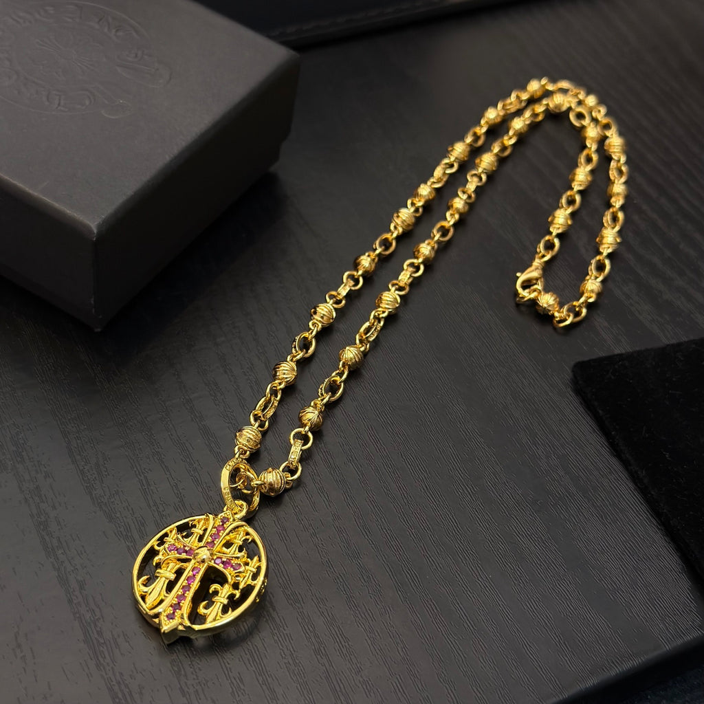 Gold-tone chain necklace with round red enamel crest pendant and linked chain.