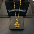 Gold-tone chain necklace with round red enamel crest pendant.