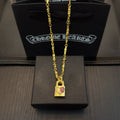 Gold-tone pendant necklace with rectangular charm featuring pink gemstone accents