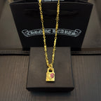 Gold-tone pendant necklace with rectangular charm featuring pink gemstone accents