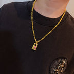 Gold-tone chain necklace worn with rectangular pink gemstone charm pendant