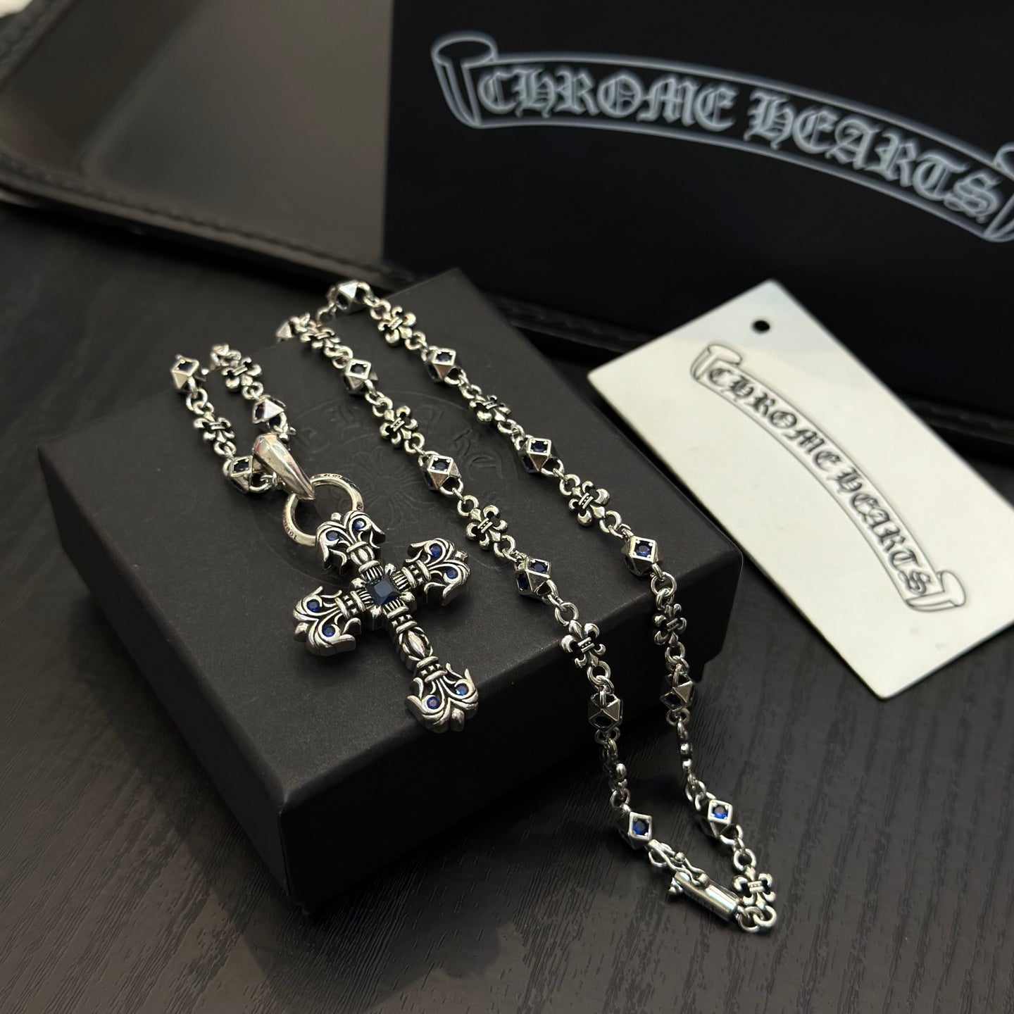 Silver-tone cross pendant necklace with blue enamel and layered chain links