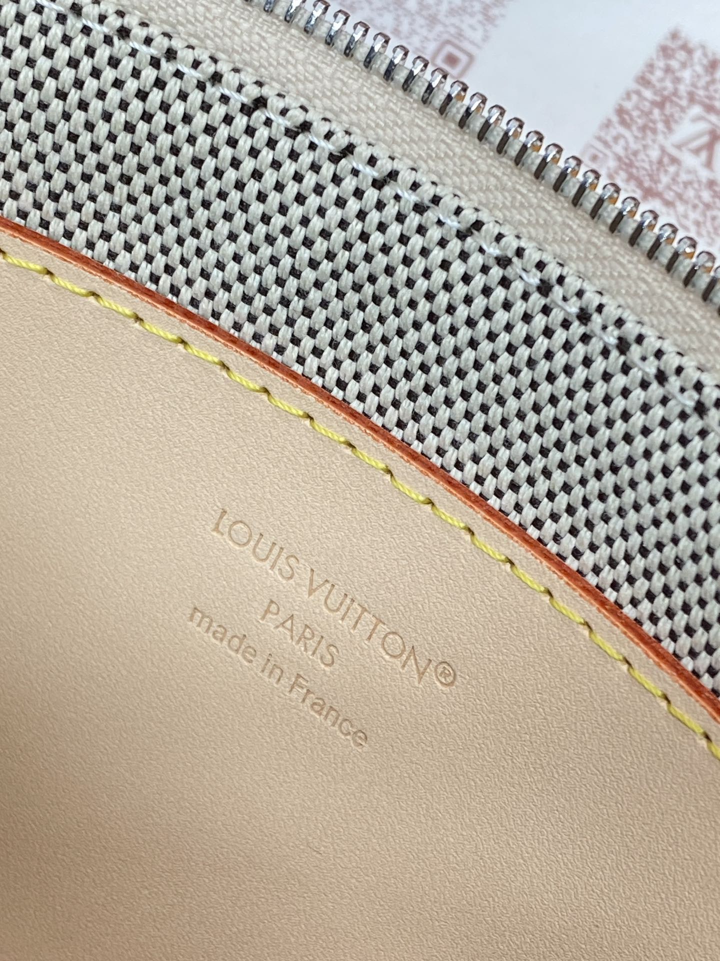 Women's small Louis Vuitton bag, beige leather trim with yellow stitching and stamped mark.