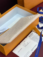 Women's small Louis Vuitton bag, textured beige canvas exterior with zip closure.