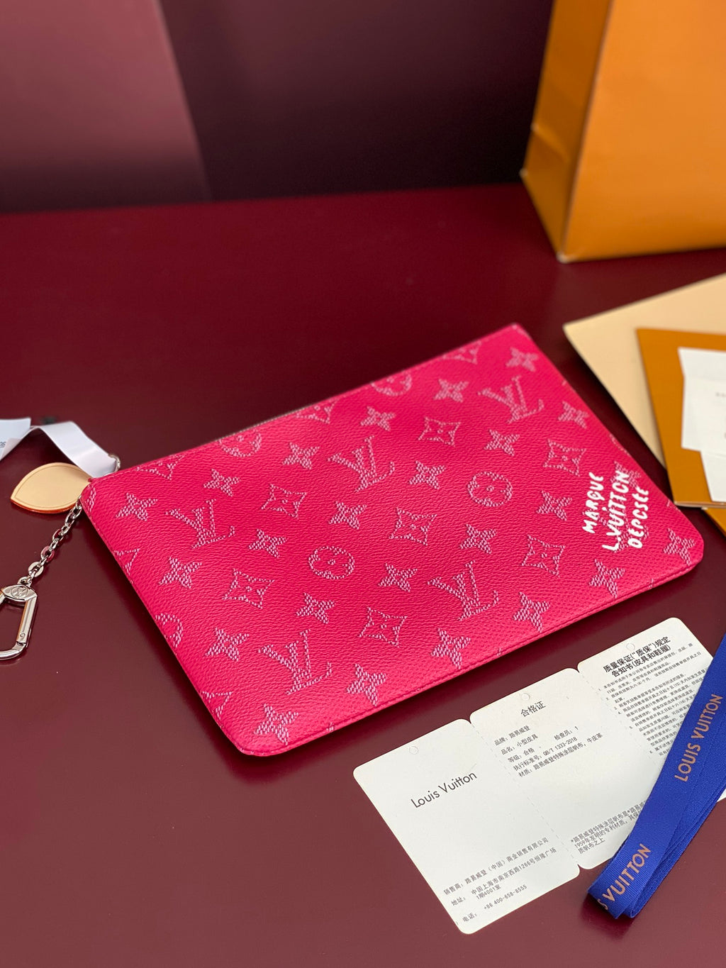Pink Louis Vuitton wristlet pouch with monogram print and silver chain key ring