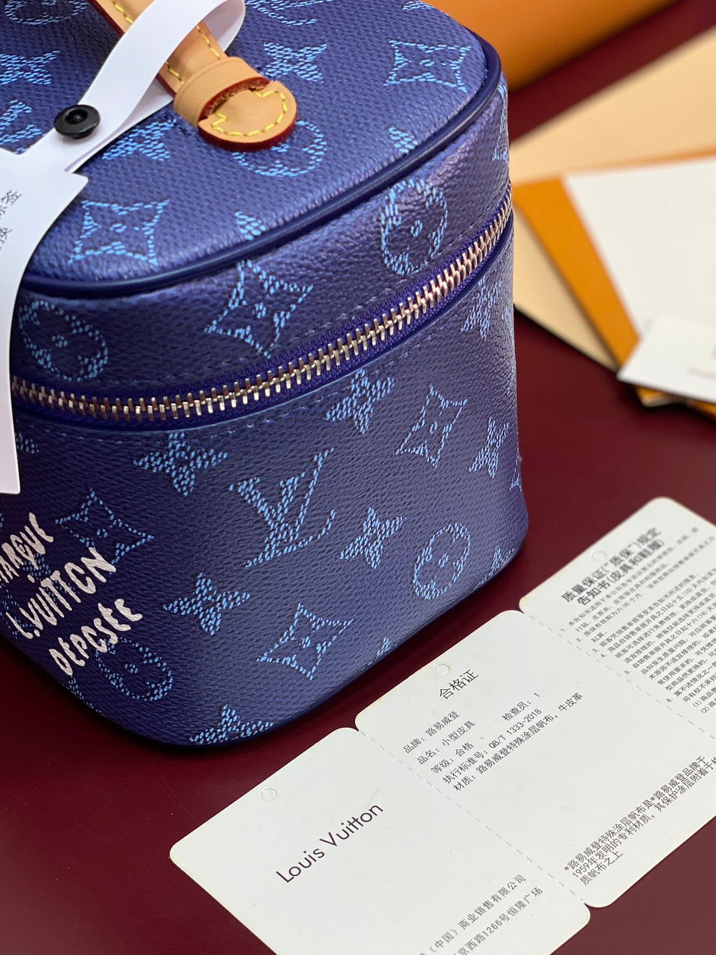 Louis Vuitton blue monogram vanity bag top view with tan trim and zip