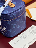 Louis Vuitton blue monogram vanity bag top view with tan trim and zip