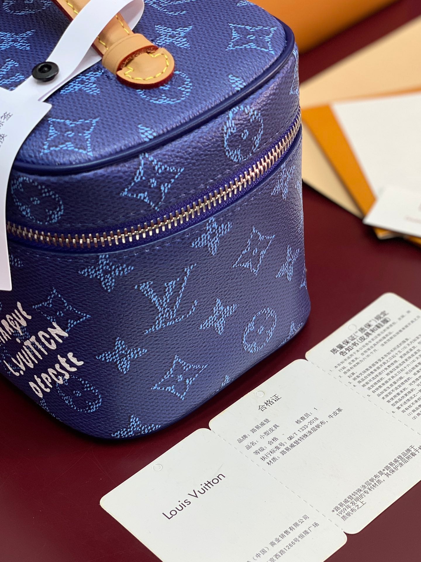 Louis Vuitton blue monogram vanity bag top view with tan trim and zip