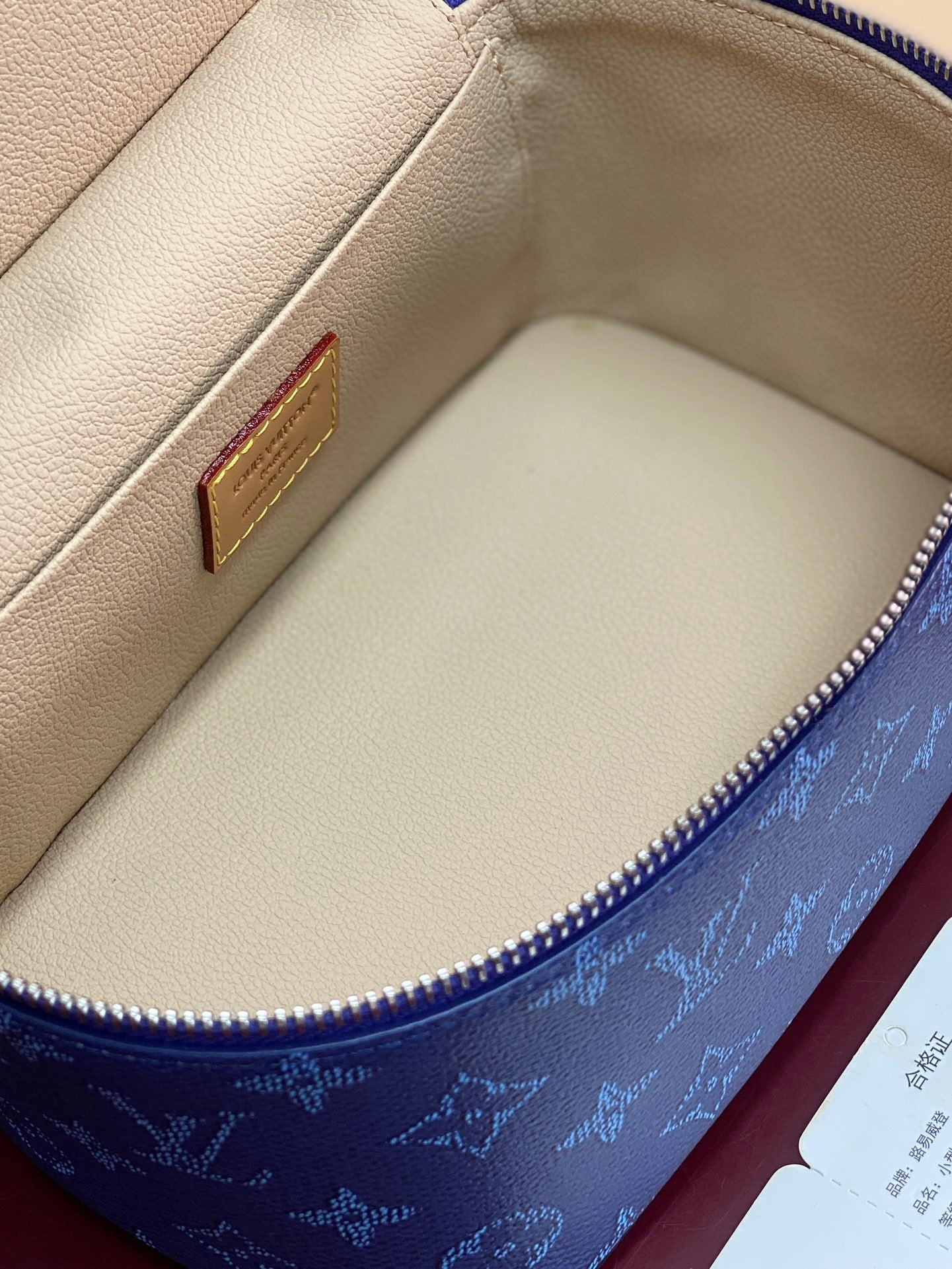 Louis Vuitton vanity bag interior with light-beige lining and gold-tone logo plate