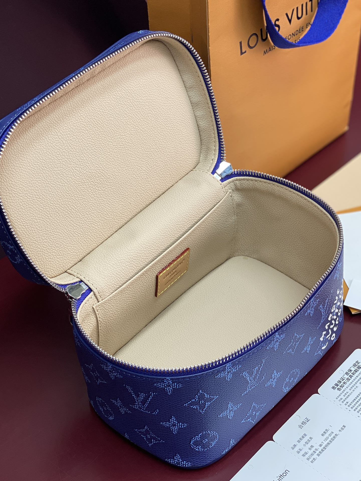 Louis Vuitton blue monogram vanity bag open to light-beige lined interior