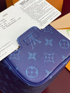 Blue monogram bag top close-up with embossed pattern and curved zip pocket edge.