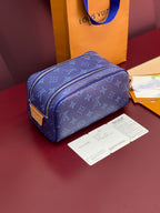 Blue monogram crossbody bag with dual zippers, gold-tone hardware, and shoulder strap.