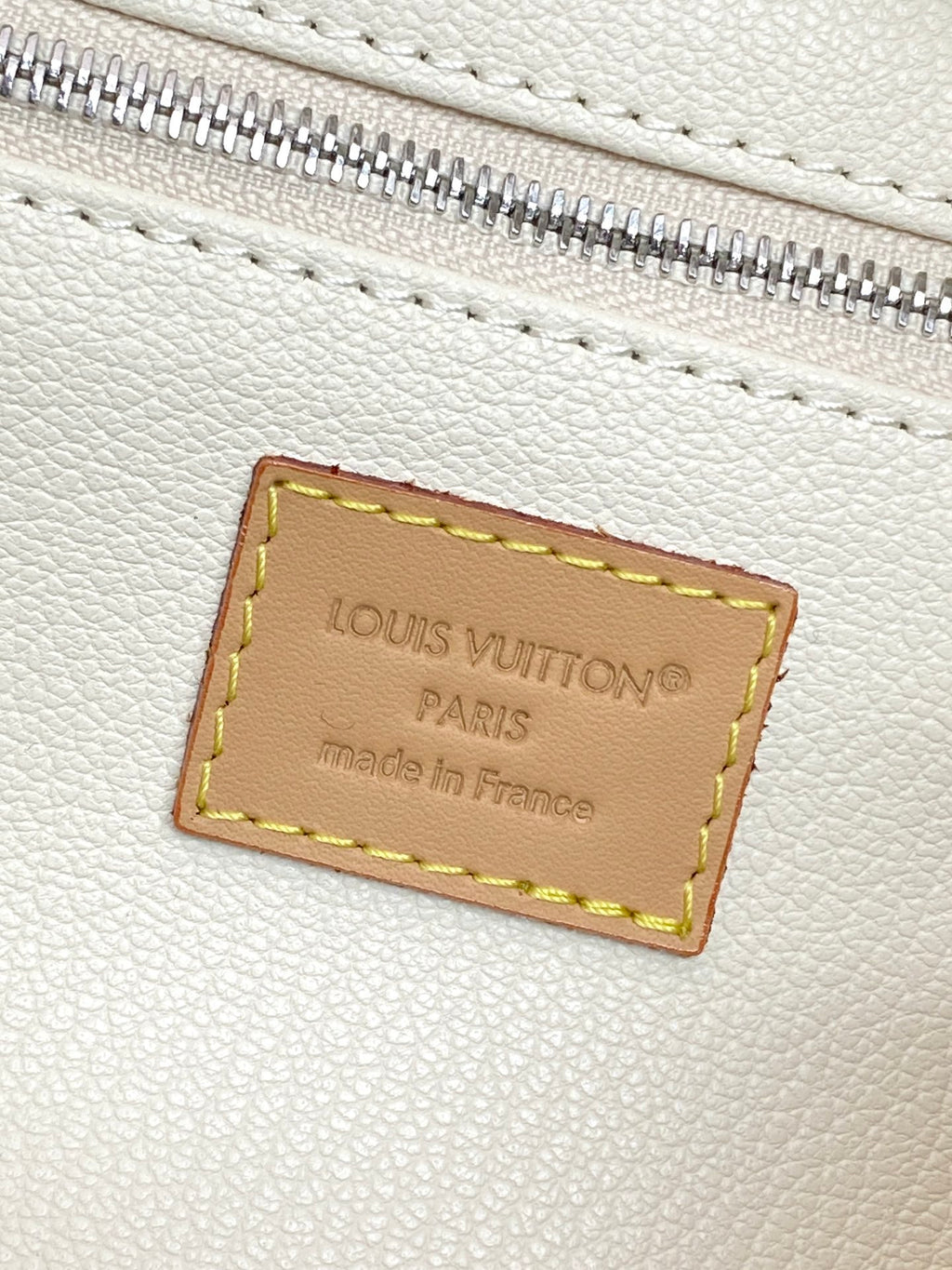 Beige leather interior label reading “LOUIS VUITTON PARIS” with made in France.
