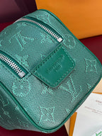 Teal Louis Vuitton bag with embossed monogram, top zipper and leather trim