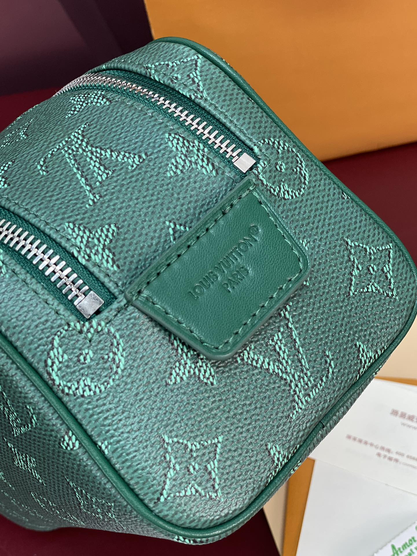 Teal Louis Vuitton bag with embossed monogram, top zipper and leather trim