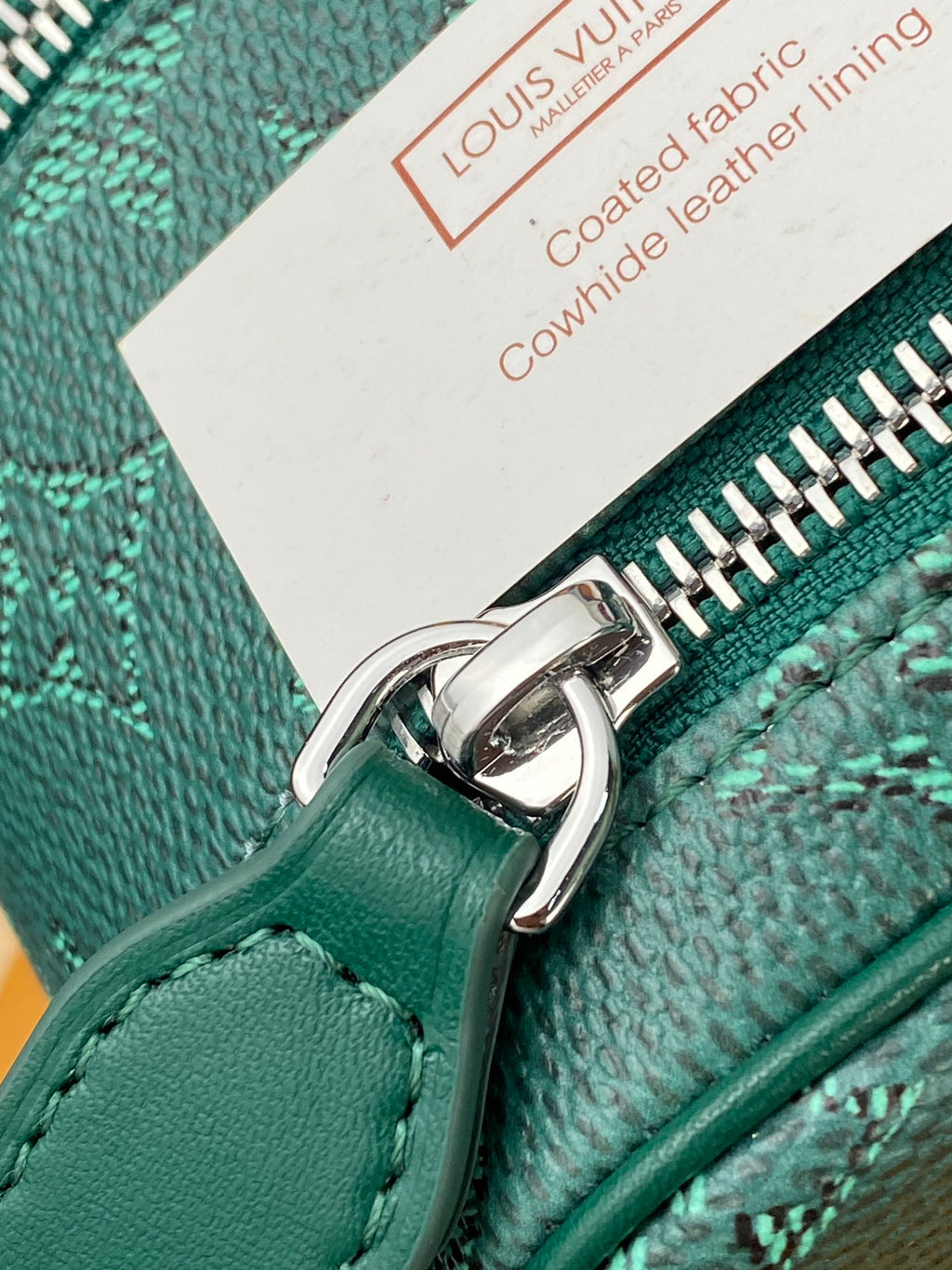 Teal Louis Vuitton bag zipper with metal ring pull and embossed logo detail