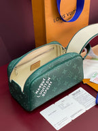 Green monogram toiletry bag shown open with beige interior and zipper.
