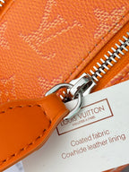 Orange monogram zip bag detail with shiny metal zipper and leather pull tab