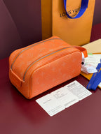 Orange monogram crossbody toiletry bag with zip closure and leather trim