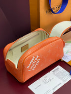 Orange monogram toiletry bag open to reveal beige lining and front zip pocket
