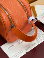 Orange monogram toiletry bag with leather strap loop and silver zipper hardware