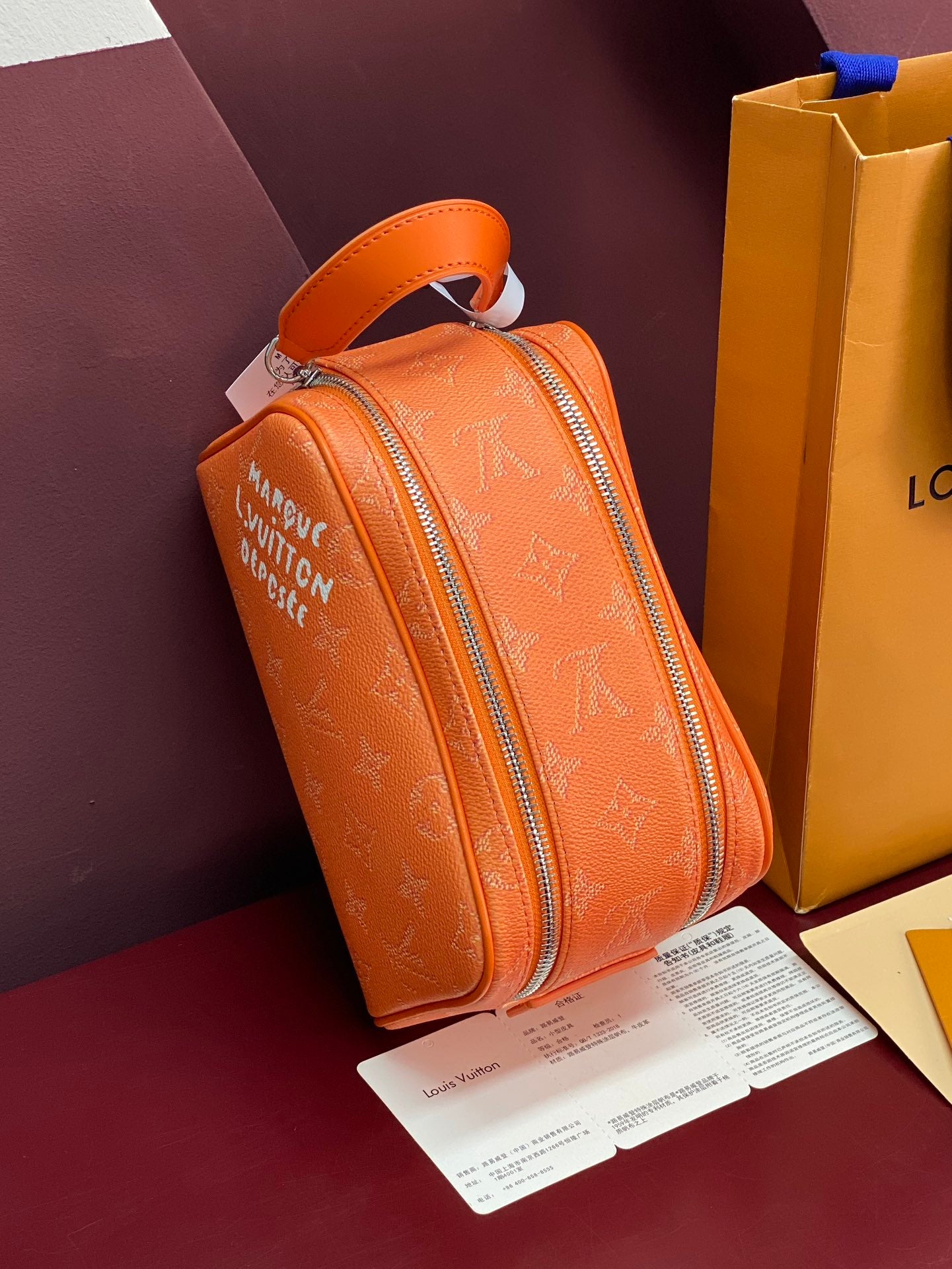 Orange monogram toiletry pouch with two zip compartments and top handle