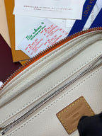 Light beige fabric lining with silver zipper teeth and stitched leather edge