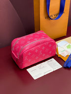 Pink monogram toiletry bag, angled view, front zip pocket and strap