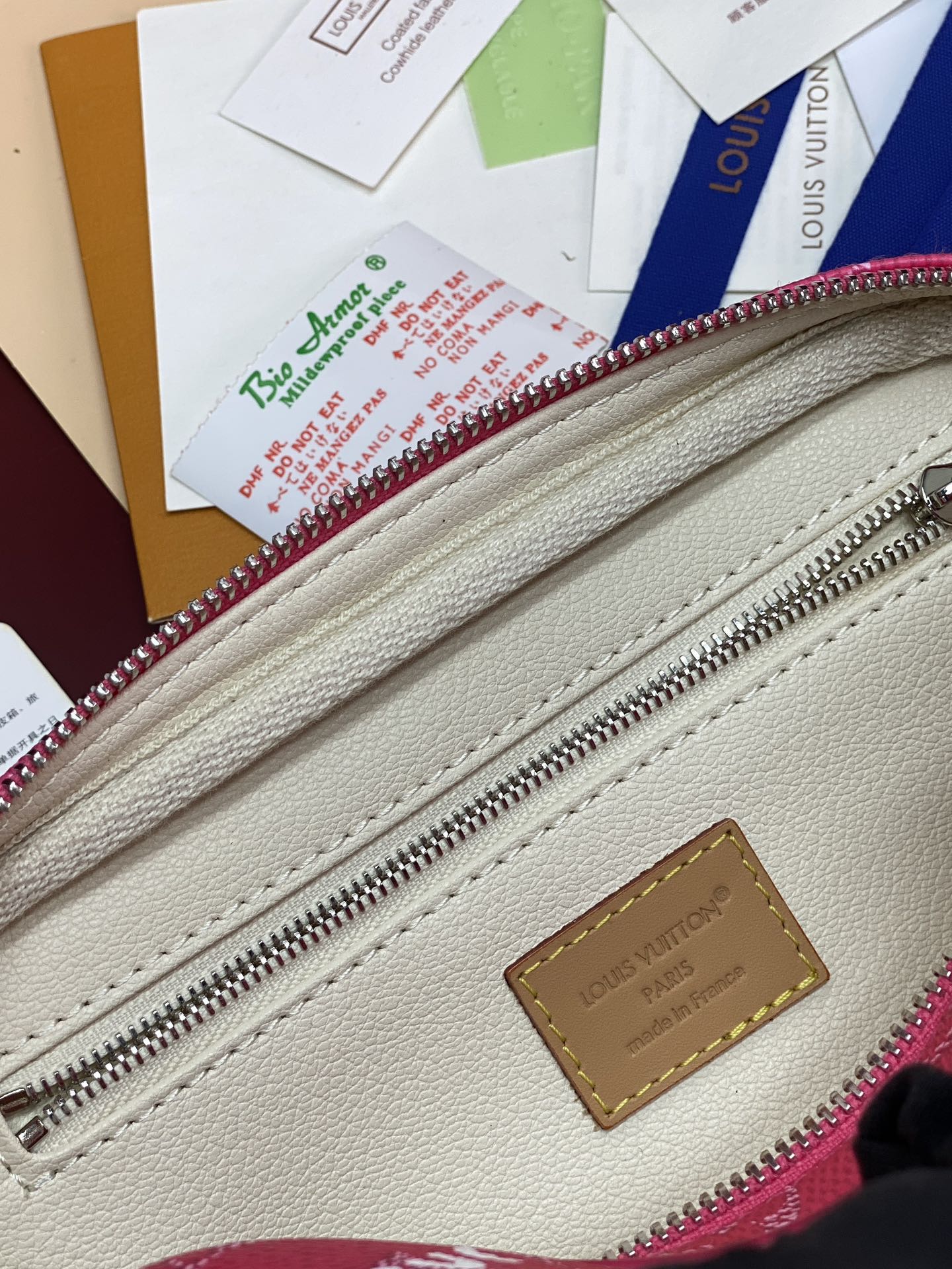 White leather interior with Louis Vuitton logo patch and pink-trim zipper