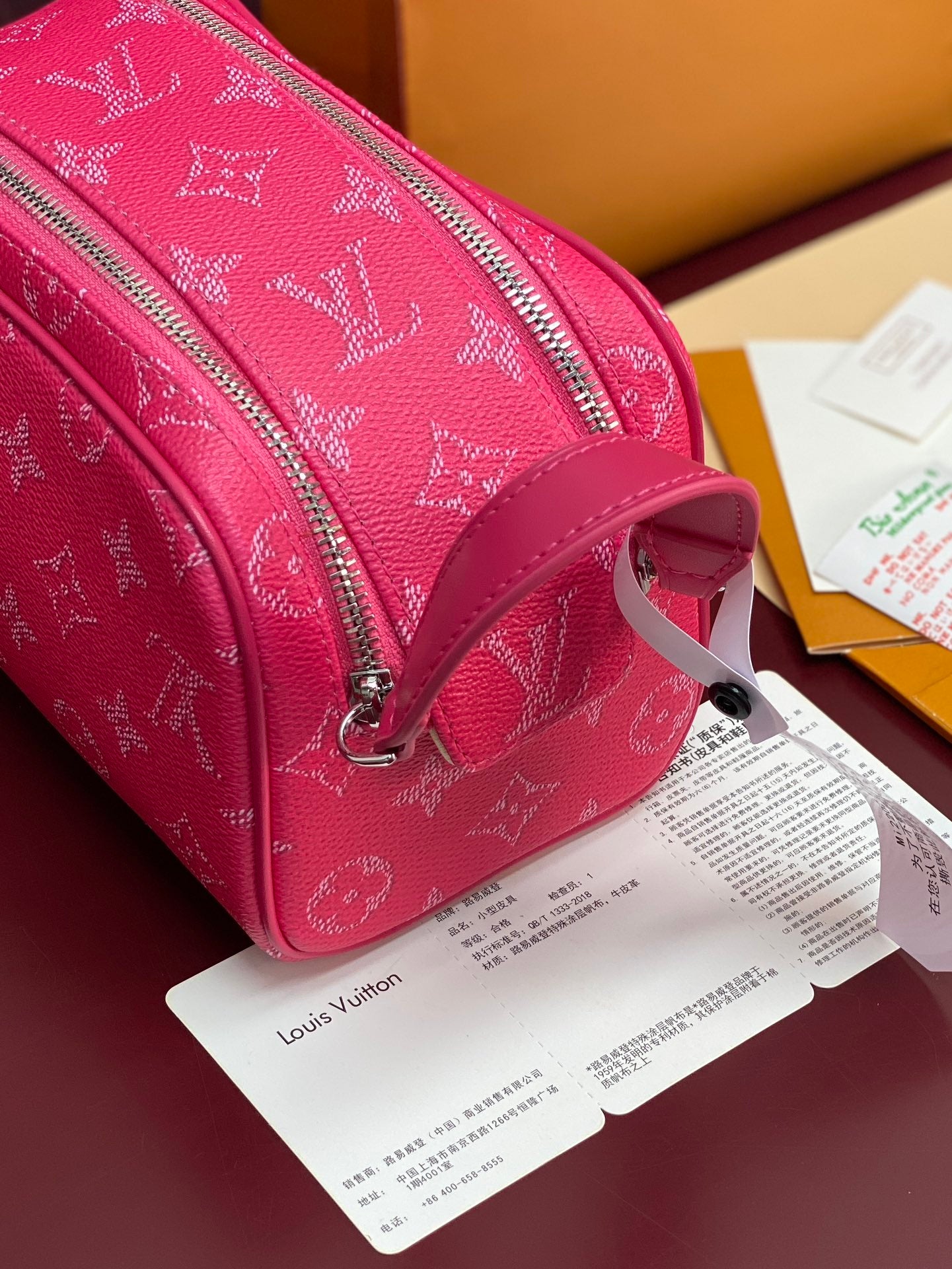 Pink monogram toiletry bag side view with top handle and silver zipper