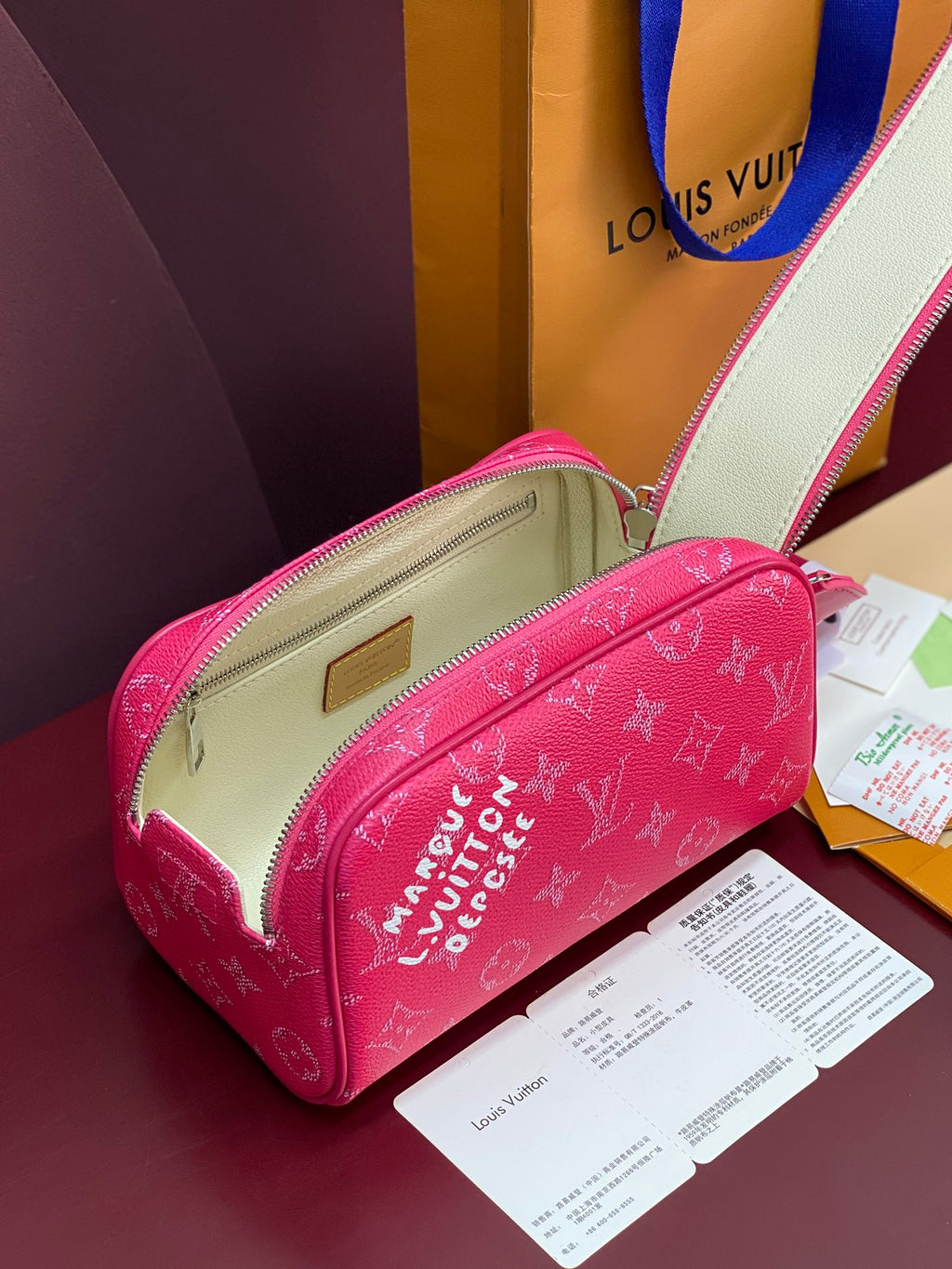 Pink monogram toiletry bag with pale lining, front zip pocket, brass logo plate