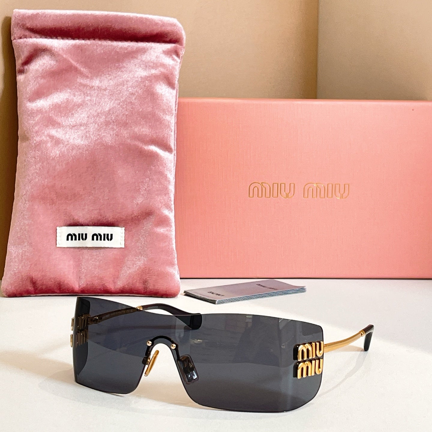 Miu Miu glasses with gold-tone frame and dark gray tinted lenses