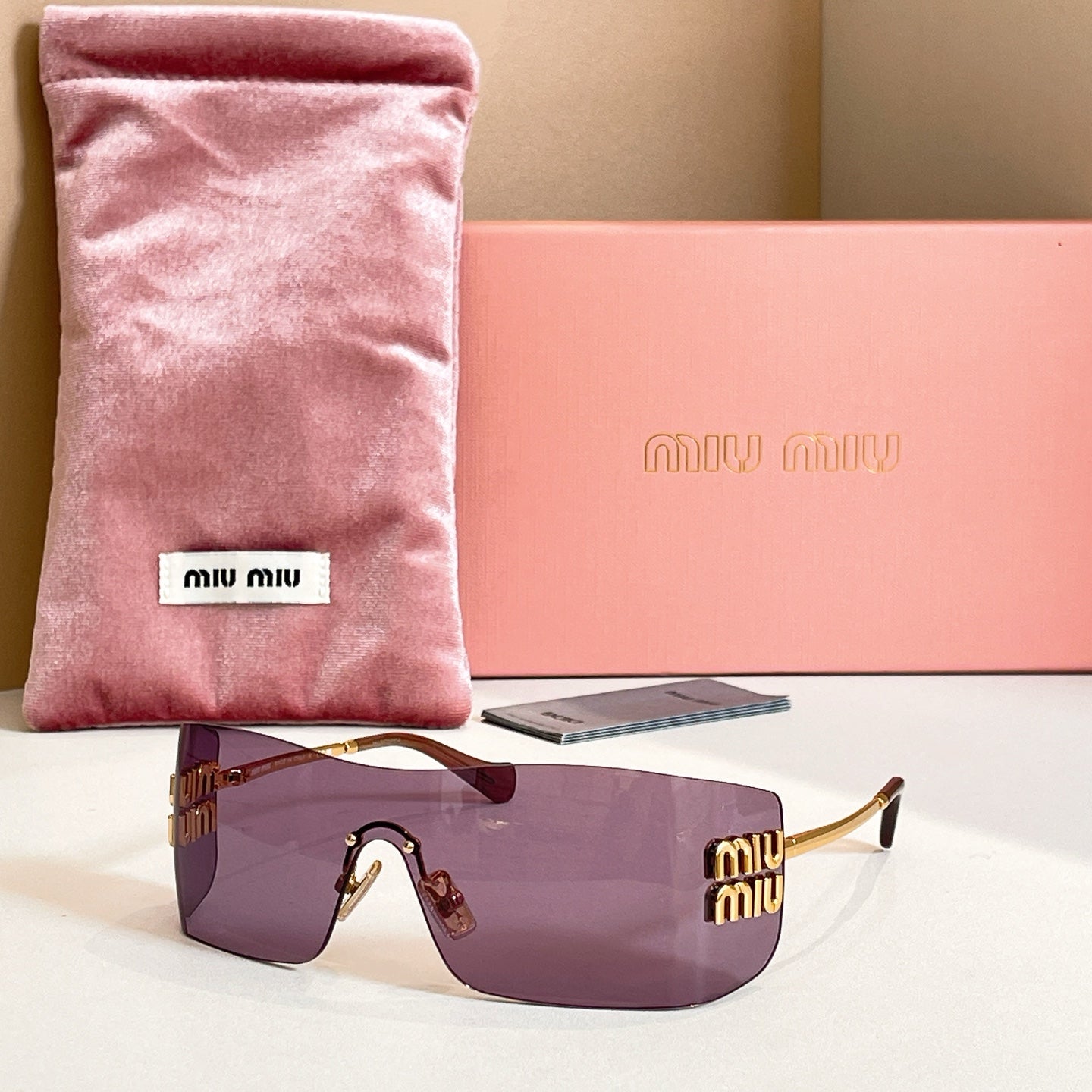 Miu Miu glasses with gold-tone frame and dark purple tinted lenses