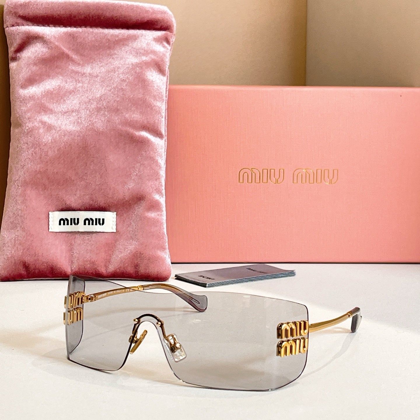 Miu Miu glasses with gold-tone frame and light gray tinted lenses