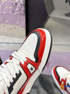 Side view of white and red Louis Vuitton sneaker with black panel and lace-up details