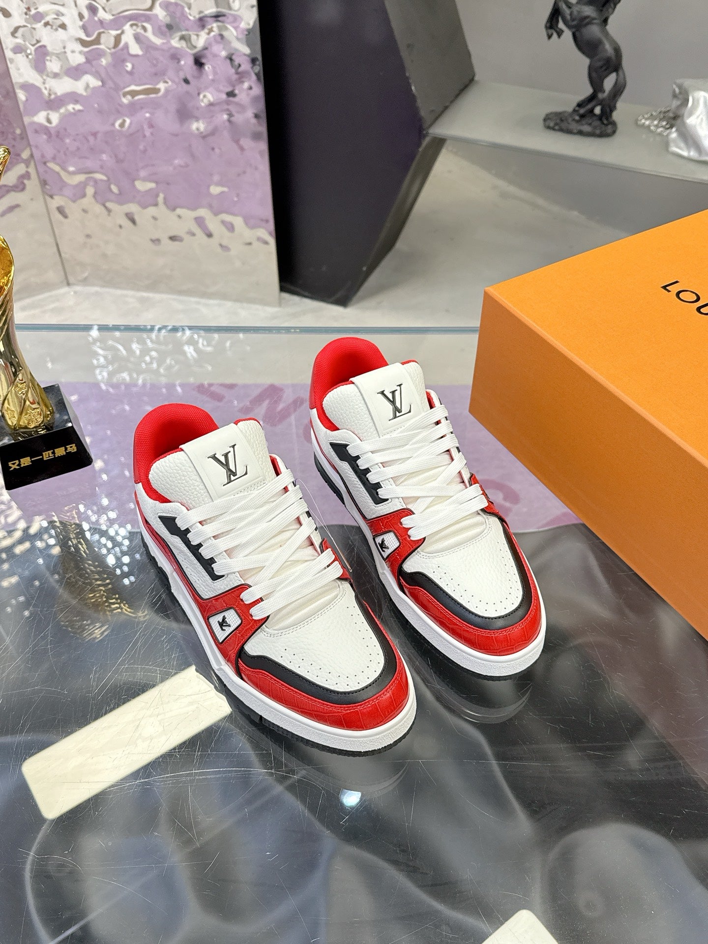 White and red Louis Vuitton low-top sneakers with black side panel, lace-up and LV logo