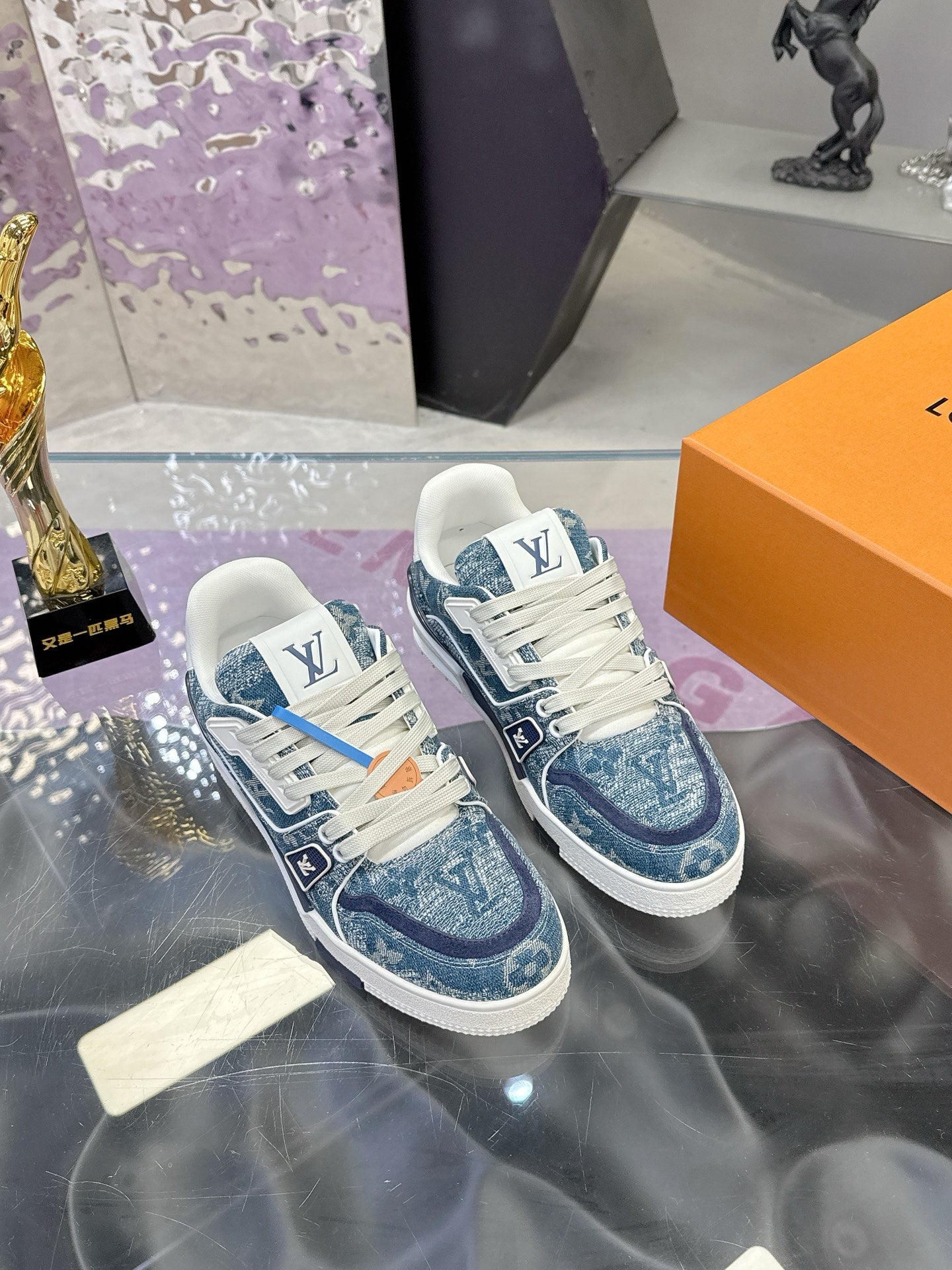 Louis Vuitton ladies sneakers, front angled view with blue patterned uppers and white laces