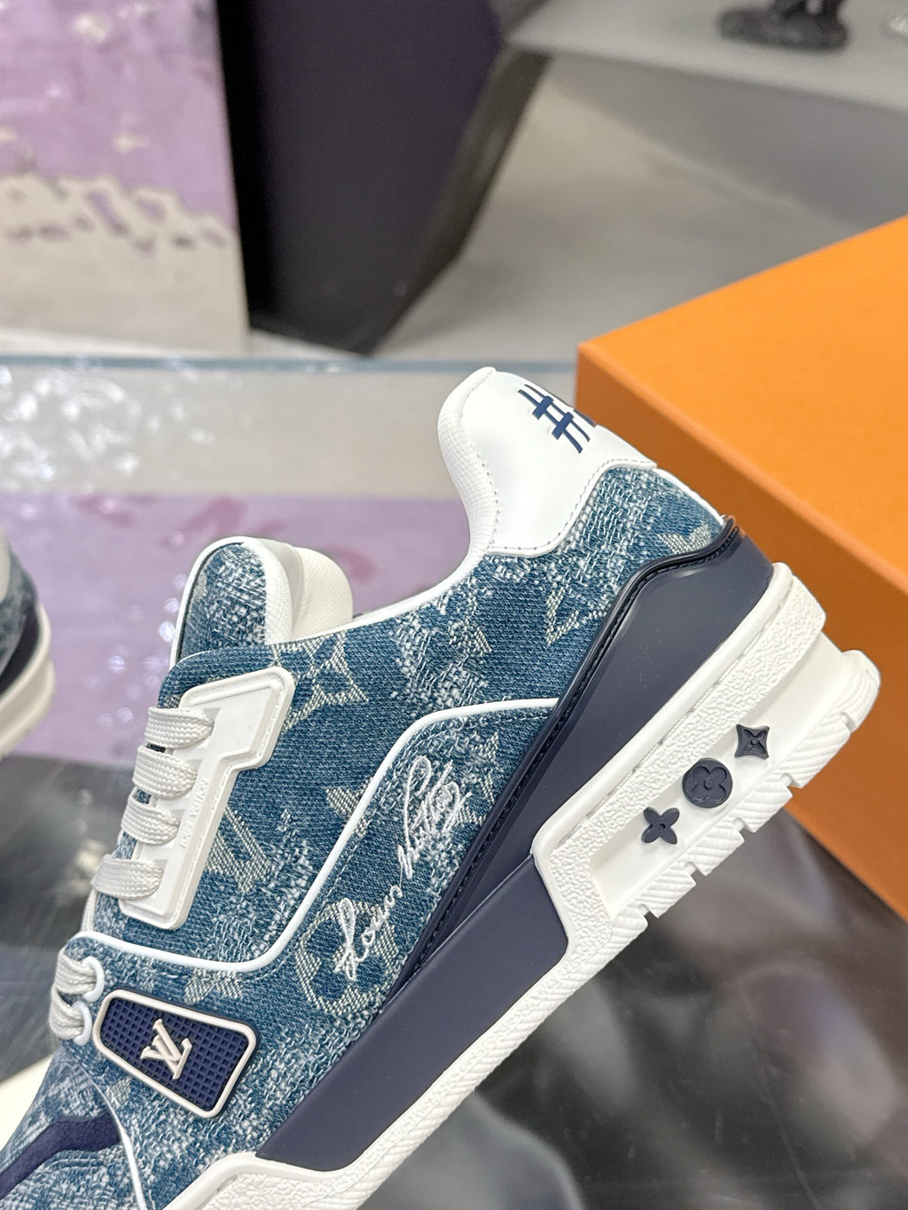 Louis Vuitton ladies sneaker with blue side panel and white laces, black heel detail