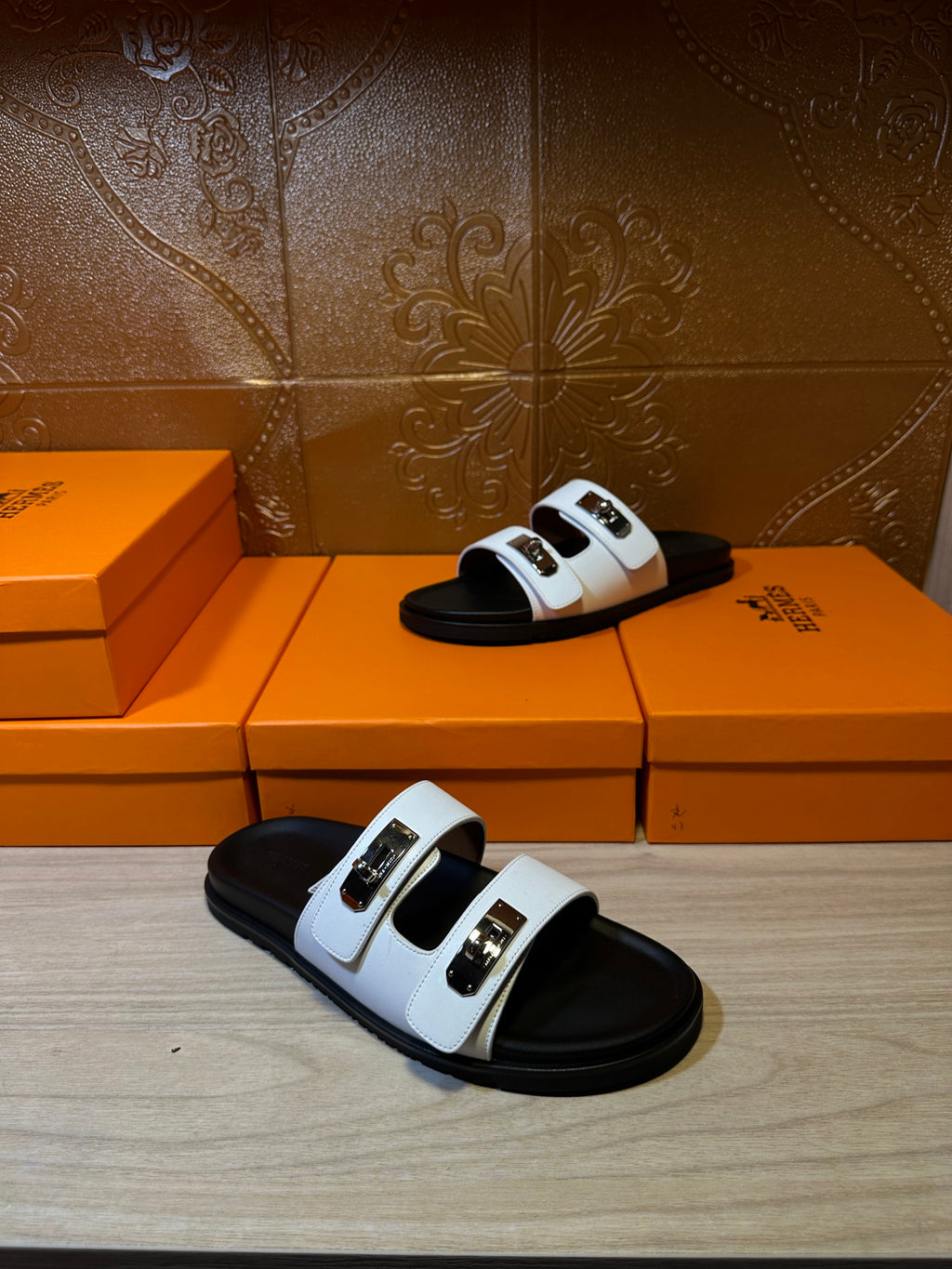Hermes two-strap sandals with white straps and black footbed, standing pair.