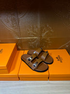 Hermes tan slide sandals with two straps and silver-tone buckles