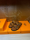Hermes tan leather slide sandals with two cross straps and metal buckles