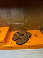 Hermes tan leather slide sandals with two cross straps and metal buckles