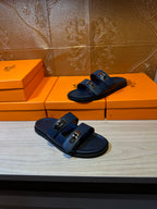 Hermes blue slide sandals with two front buckles, one pair foreground on boxes