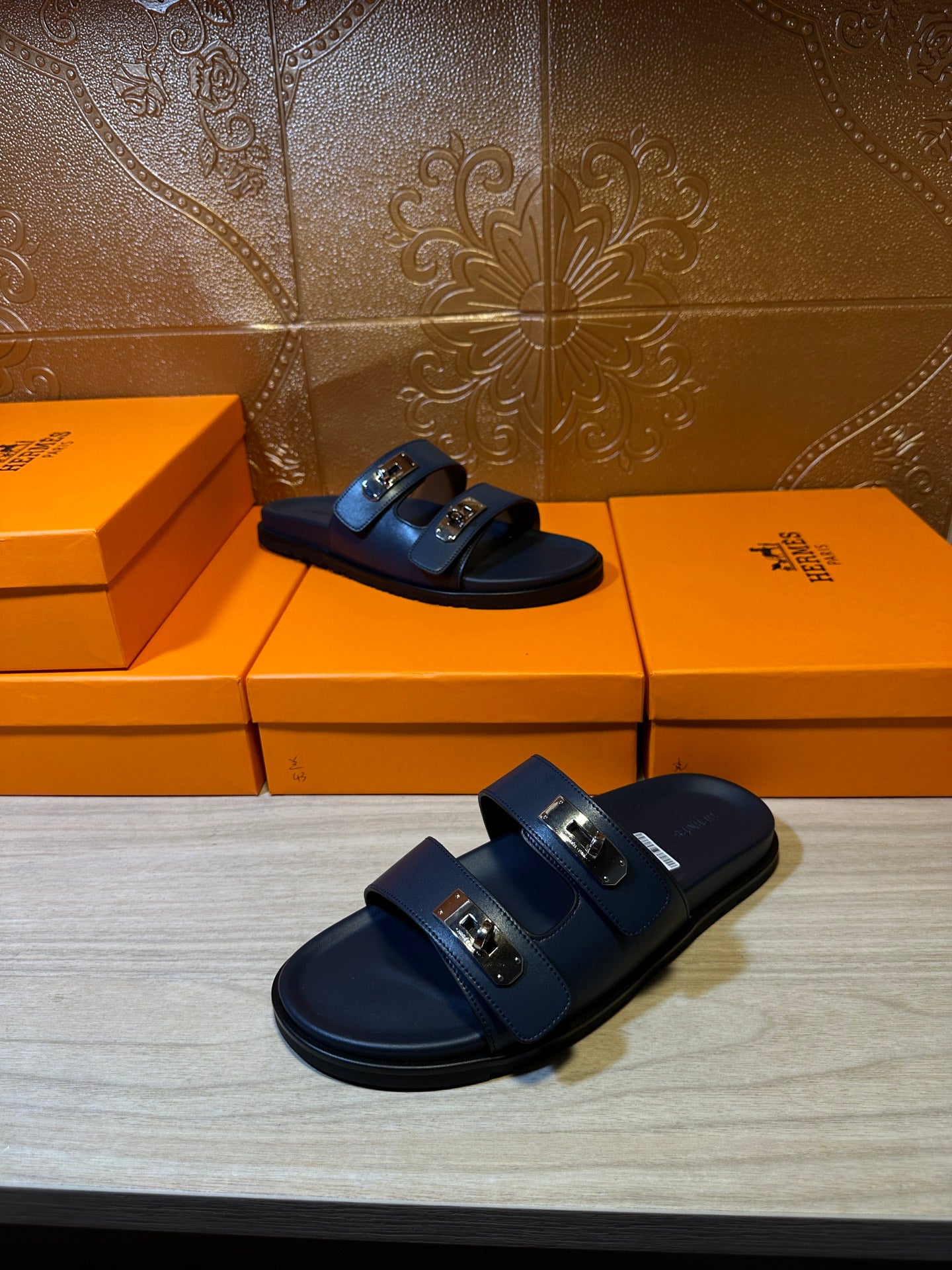 Hermes blue slide sandals with two front buckles, three-quarter view