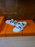 Hermes white sandals with two wide straps and shiny metal buckles, open toe