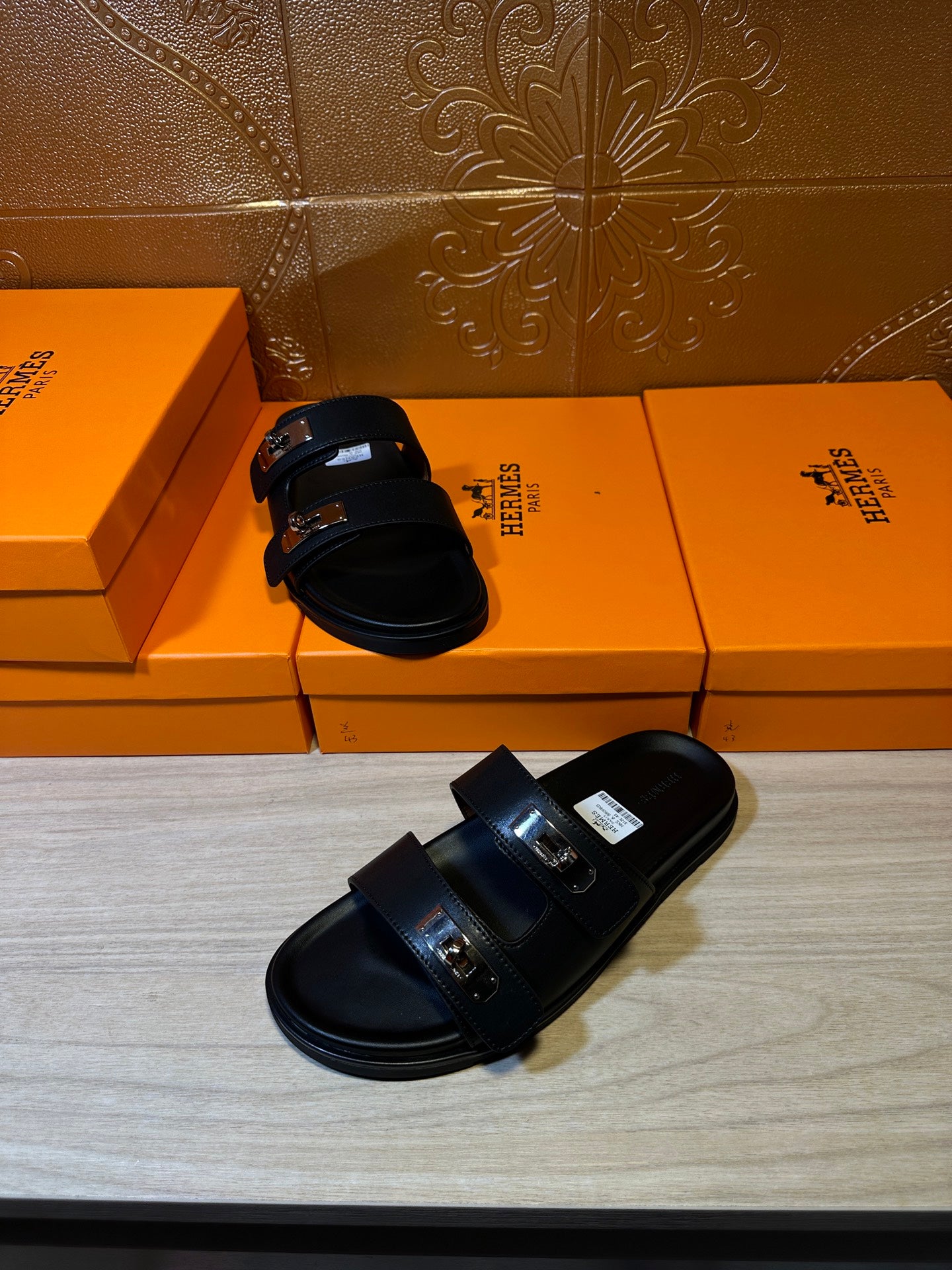 Black sandals, side view, with two straps and metal buckle at the instep.