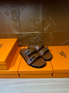 Tan leather double-strap slide sandals with silver buckles and open toe