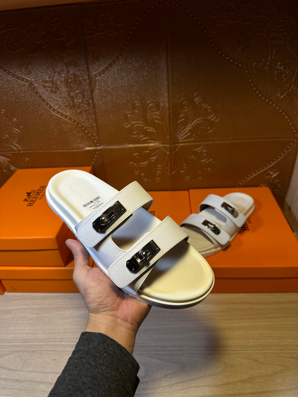 White Hermes slide sandals shown front, double straps with silver buckle detail